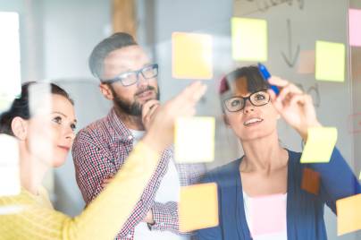 Persone che guardano post it su una lavagna