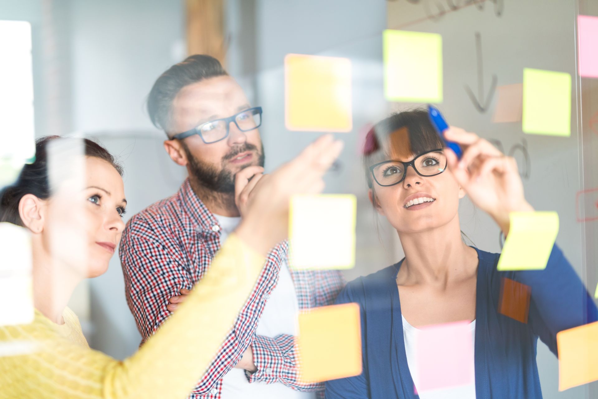 Persone che guardano post it su una lavagna